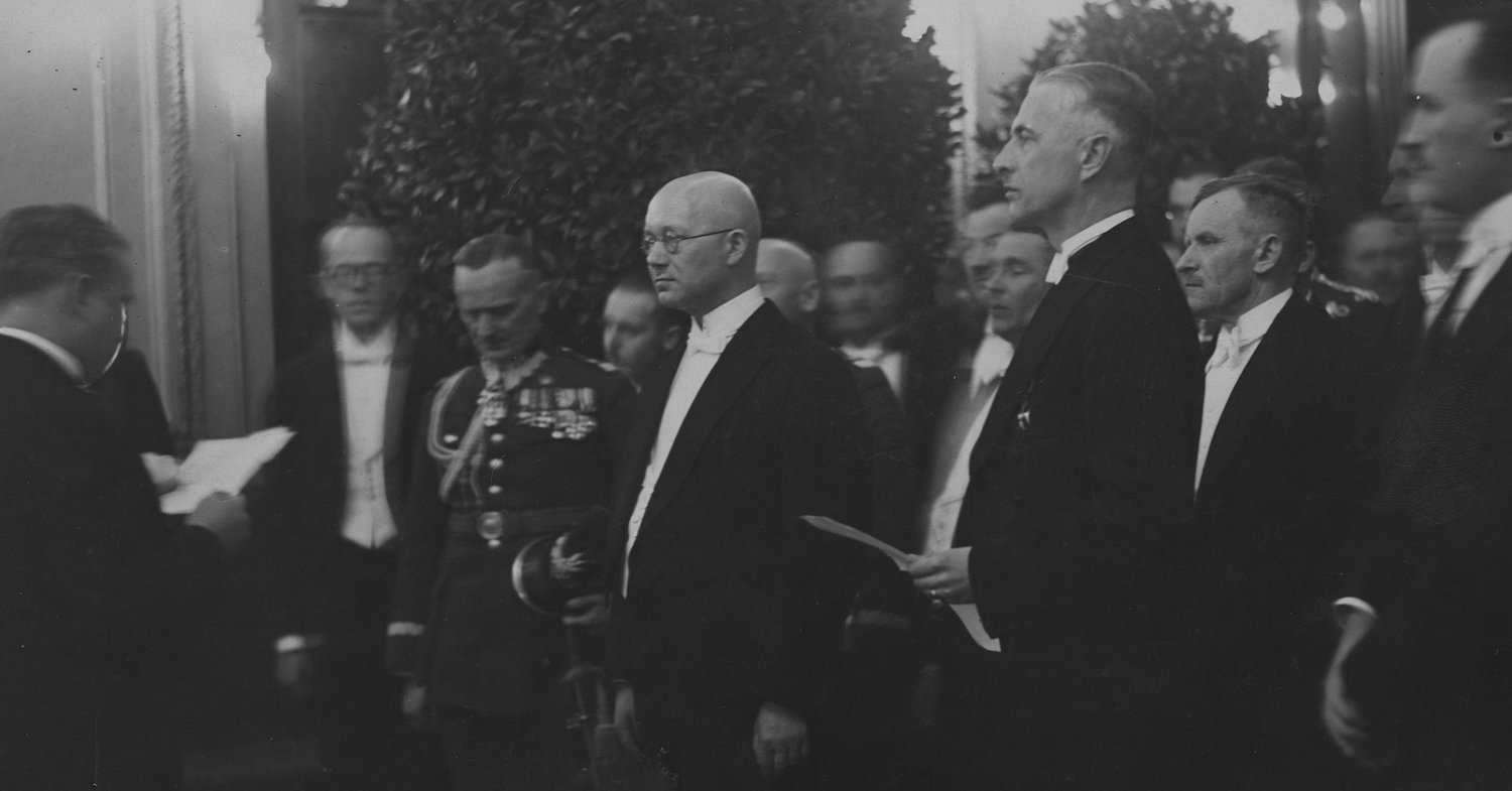 Prezydent Wilna Józef Folejewski odczytuje tekst przemówienia podczas powitania naczelnika państwa estońskiego Otto Strandmana (w środku w okularach) w salonie dworca. Obok widoczni: wojewoda wileński Władysław Raczkiewicz (3. z prawej), dyrektor Departamentu Politycznego MSZ Estonii Johan Leppik (z lewej w okularach) oraz minister spraw zagranicznych Estonii Johan Lattik (2. z prawej). Zdj. Narodowe Archiwum Cyfrowe.